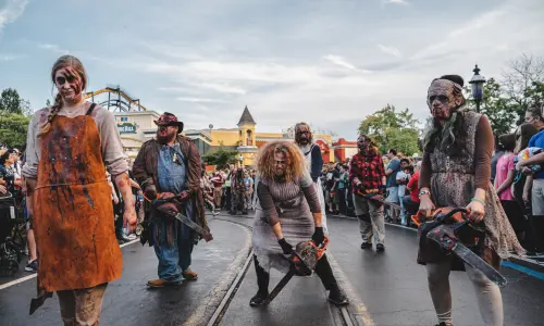 Un gruppo di zombie attraversa il parco Six Flags