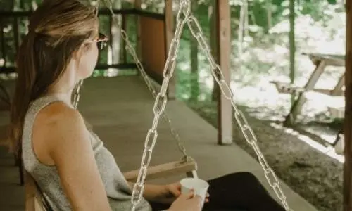 Donna seduta su una sedia sospesa sul ponte delle cabine