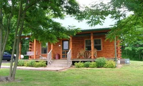 Una capanna di legno dietro alberi verdi