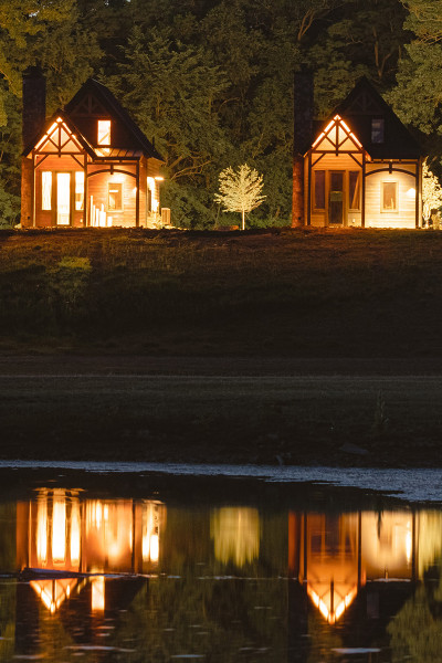 Quattro cabine illuminate di notte, riflesse nell'acqua