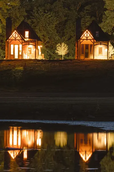 Quattro cabine illuminate di notte, riflesse nell'acqua