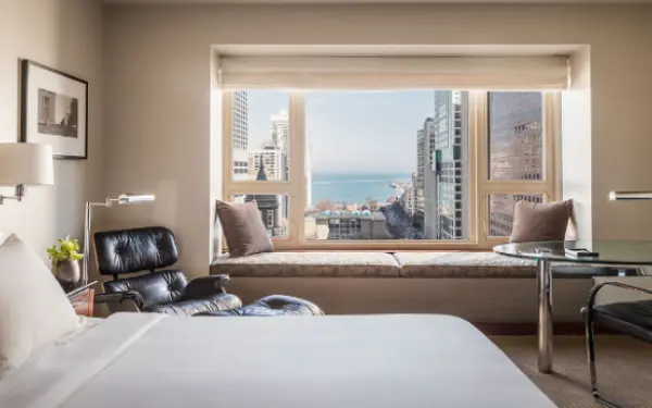 Camera d'albergo con una grande finestra che si affaccia sulla città.
