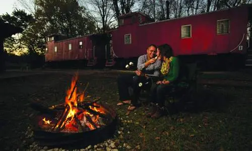 Una coppia mangia accanto a un pozzo di fuoco