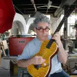 Ian Schneller strimpella una chitarra da lui stesso costruita.