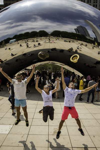 Tre persone che saltano in aria davanti al punto di riferimento The Bean a Chicago