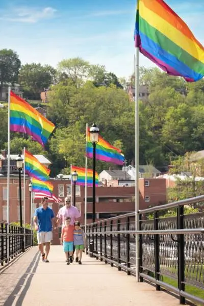 Le persone camminano lungo un ponte a Galena tappezzato di bandiere lgbt