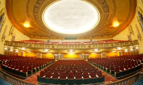 Un auditorium teatrale ornato su due livelli, visto dal palcoscenico