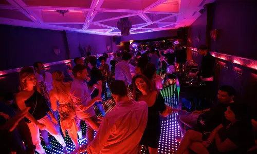 Gli avventori ballano su una pista da ballo illuminata