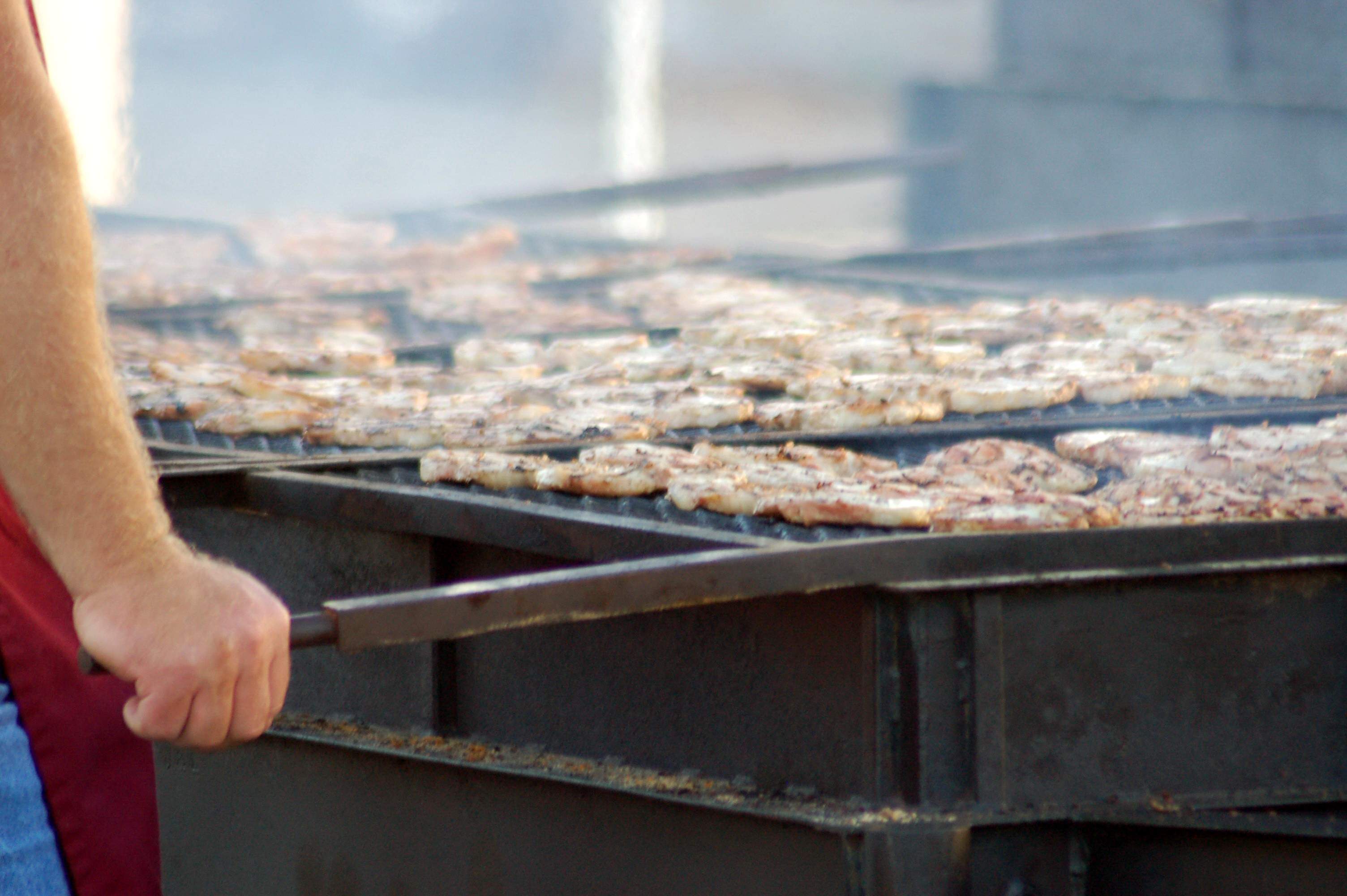 Un cuoco al barbecue che griglia costolette di maiale ai Kewanee Hog Days