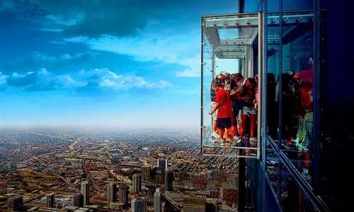 Persone in piedi sullo sky deck che guardano gli edifici sottostanti