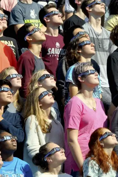 Le persone guardano il cielo durante l'eclissi solare