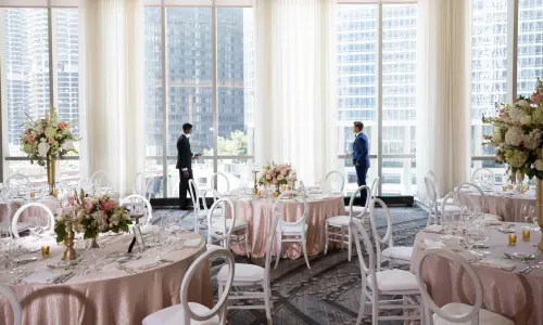 Due uomini in sala da pranzo addobbata per un matrimonio