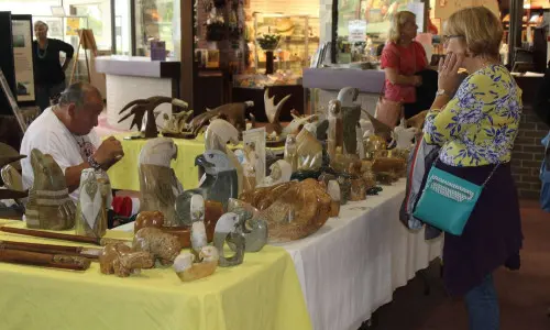 Una donna sfoglia le opere d'arte in un mercatino natalizio