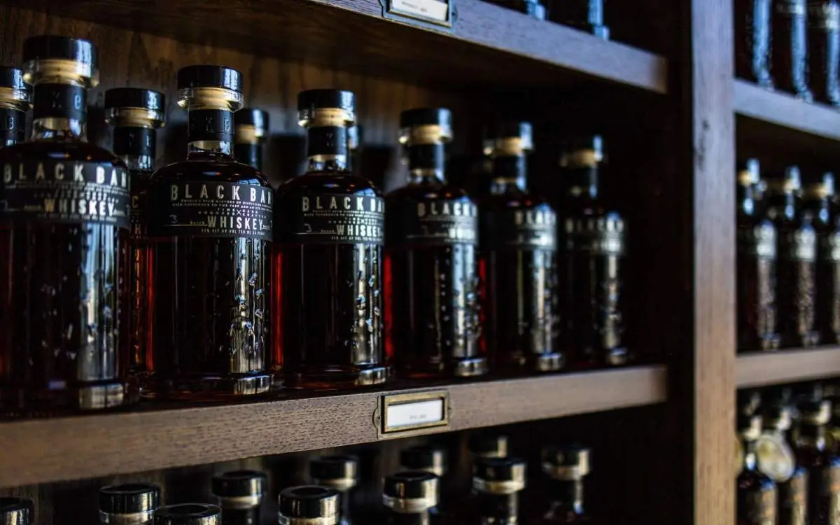 Bottiglie di whisky impilate su scaffali