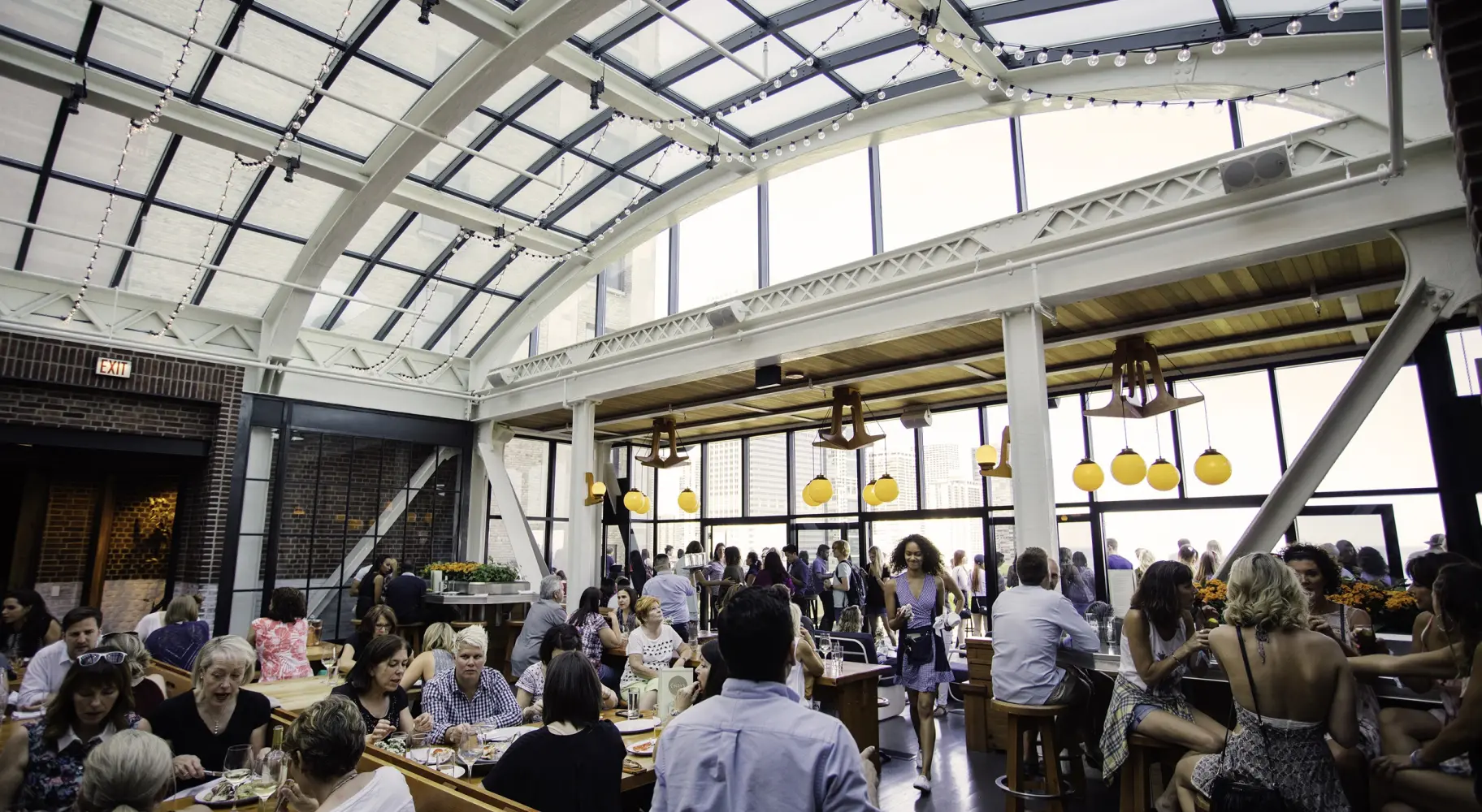 Una folla di persone sotto l'atrio di vetro del bar panoramico Cindy's