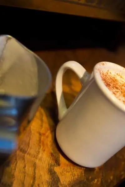 Una tazza di caffè riempita fino all'orlo con un latte speziato alla zucca.