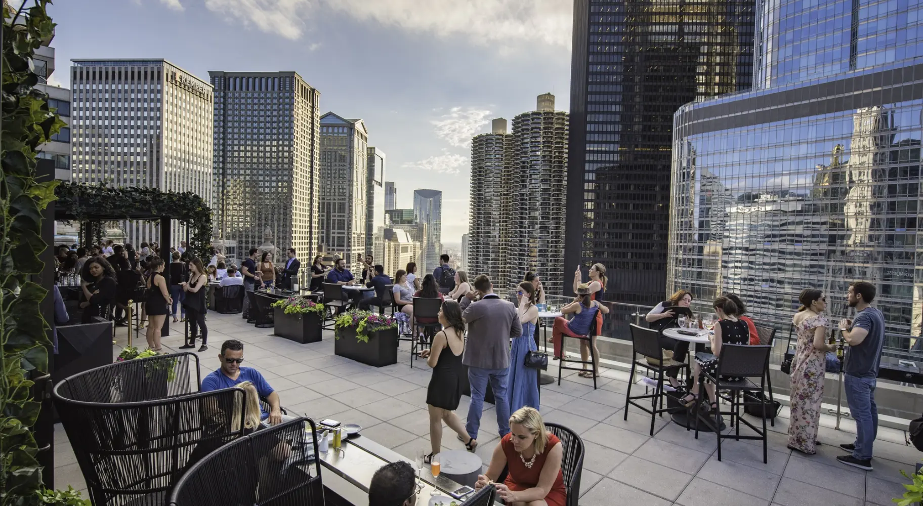 Persone riunite in un bar sul tetto tra le cime dei grattacieli