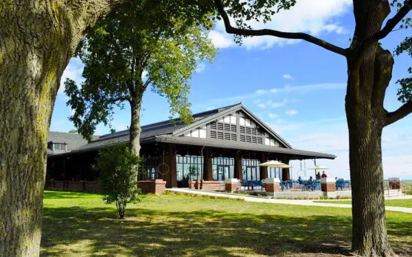 L'esterno di un ristorante sul lago con alberi in primo piano 