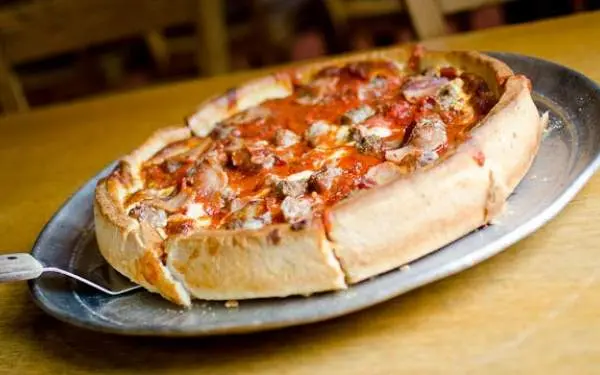Una pizza al piatto su un piatto da portata di Papa Dels.
