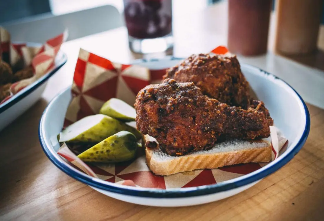 Due cosce di pollo e sottaceti su un pezzo di pane