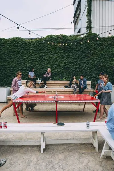 Gli avventori bevono birre e giocano a ping pong all'aperto