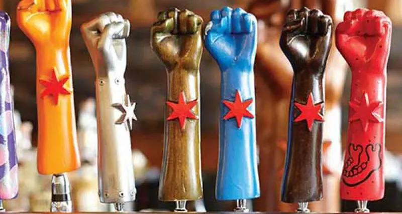 Una linea di sette maniglie per birra Revolution Brewing a forma di pugno 