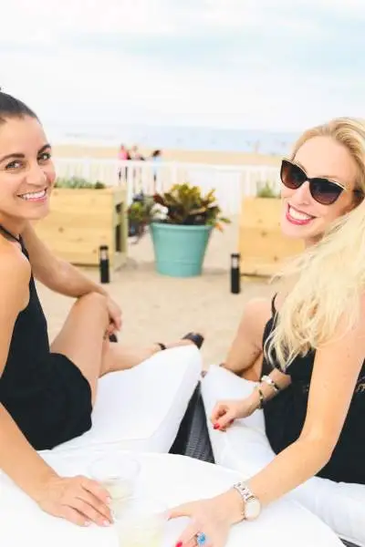 Due donne che bevono un drink su un lettino da spiaggia