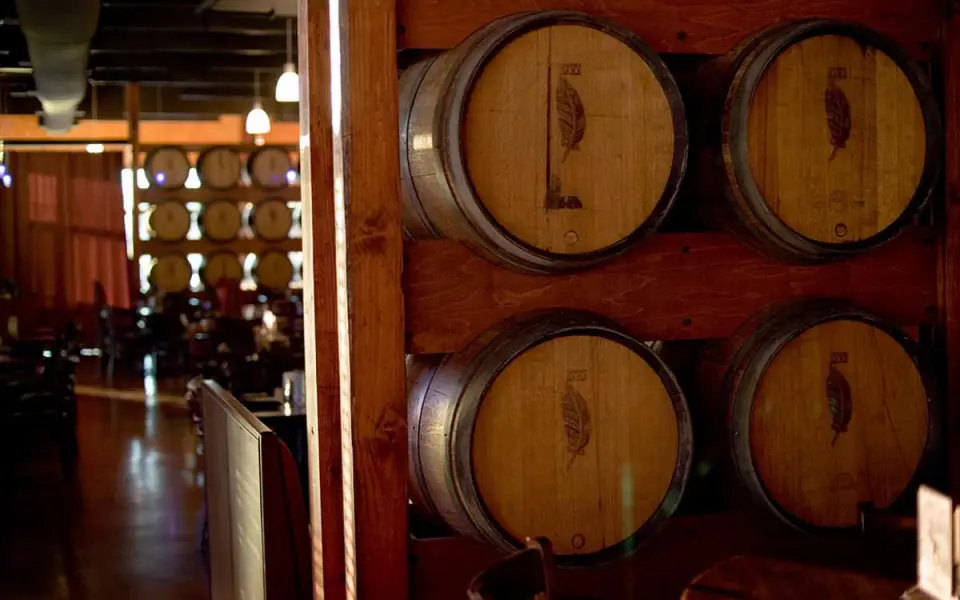 Una fila di botti di vino in una stanza buia