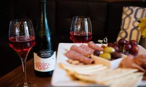 Un piatto di formaggi e un paio di bicchieri di vino seduti su un tavolo