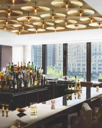 Interno di un bar con molte finestre che danno sulla città.