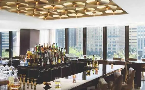 Interno di un bar con molte finestre che danno sulla città.