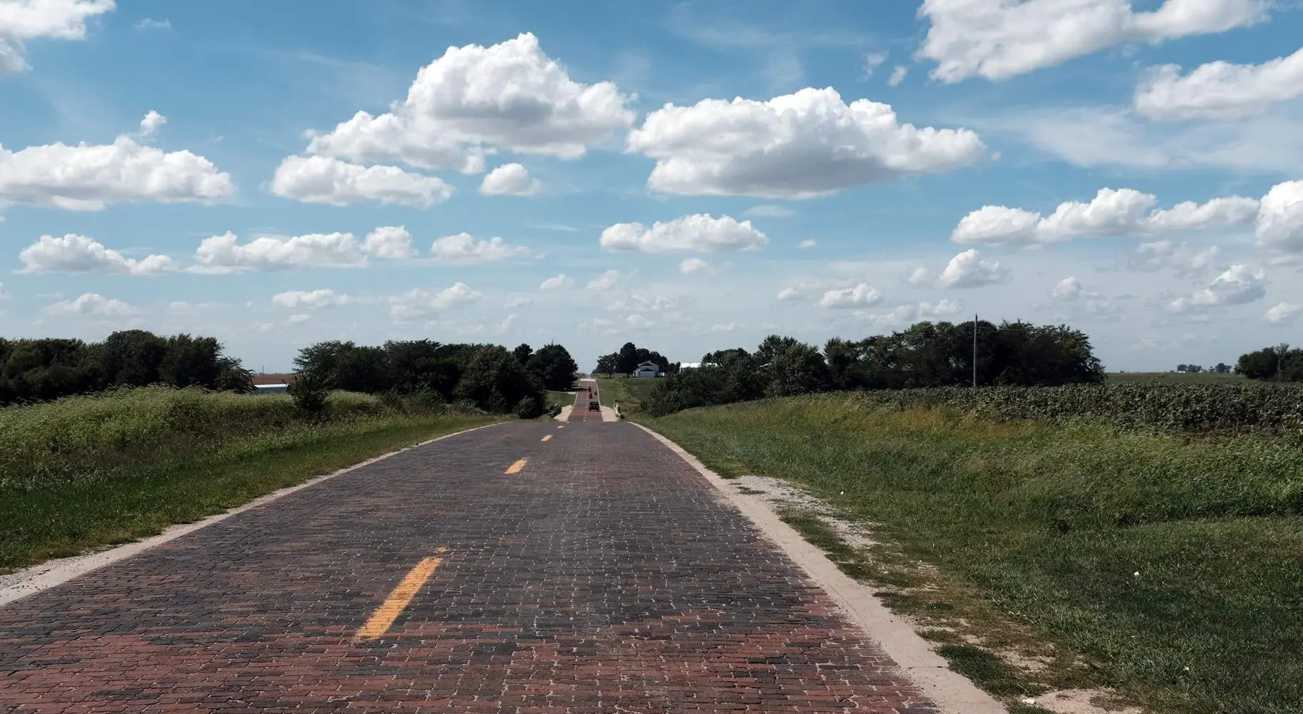 Una strada di mattoni in stile antico tra verdi campi rurali