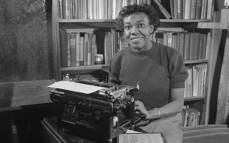 Donna seduta a scrivere in biblioteca