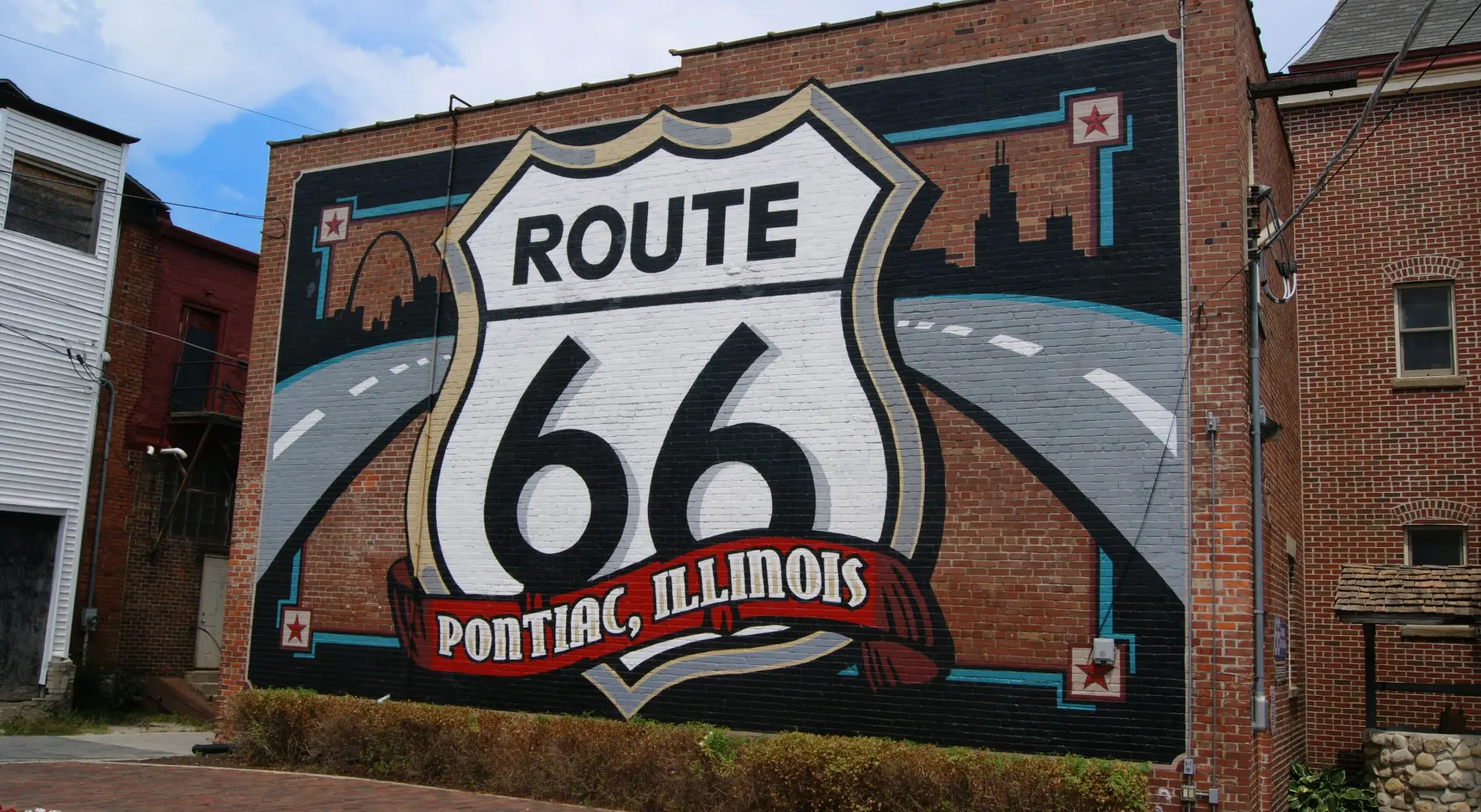 Un muro di mattoni con un grande murale sulla Route 66