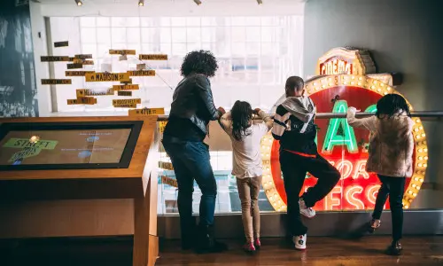 Bambini e adulti affacciati a una ringhiera 