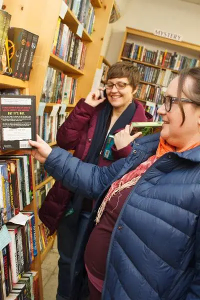Donne in libreria che guardano uno scaffale di libri