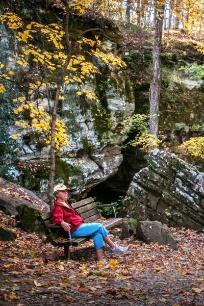 Persona seduta su una panchina nella foresta