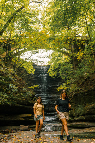 Due ragazze passeggiano davanti a una cascata nel Matthiessen State Park