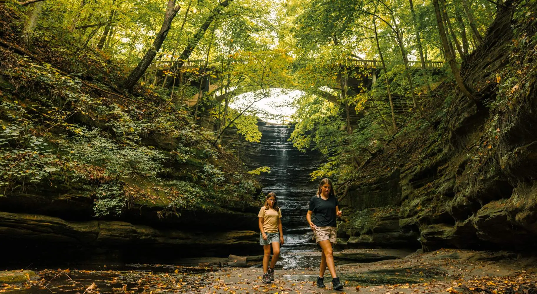 Due ragazze passeggiano davanti a una cascata nel Matthiessen State Park