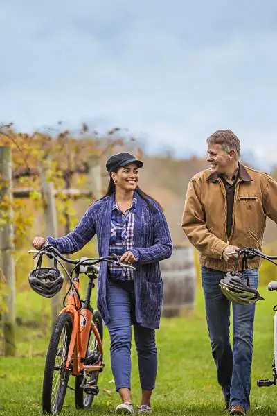 Una coppia a passeggio con la bicicletta tra le vigne