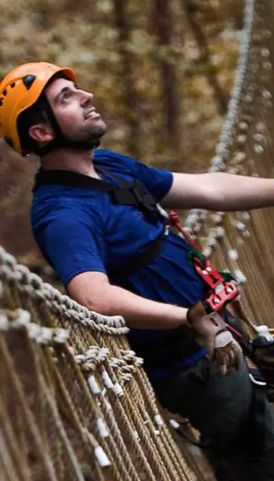 Scalatori con imbracatura che attraversano un ponte.