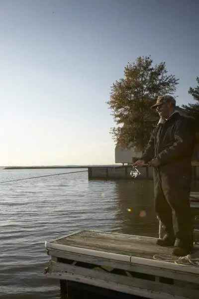 Pescatore che pesca durante l'alba al lago Rend.