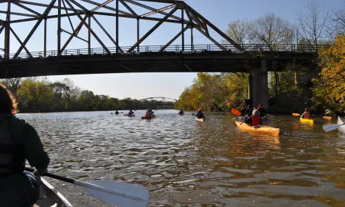 Un gruppo di persone che pagaia lungo il fiume in canoa