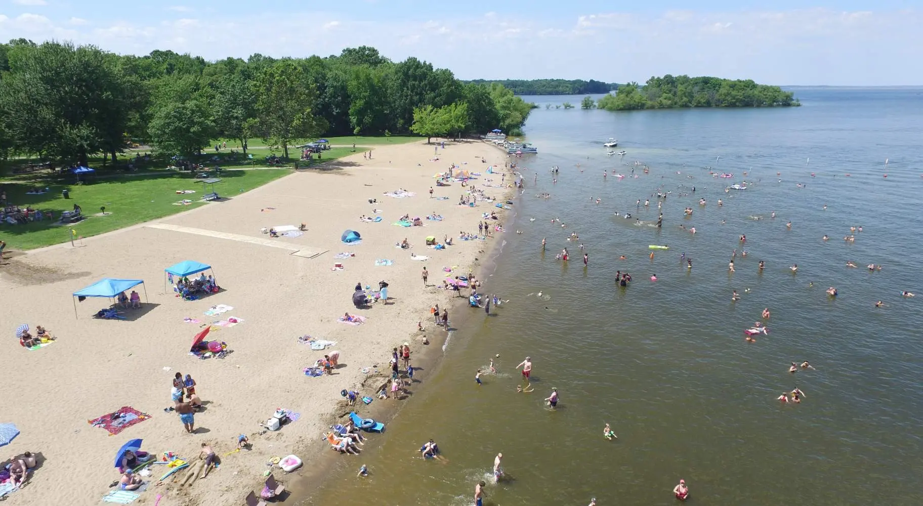 Una veduta aerea di una spiaggia con persone che si godono il sole, la sabbia e l'acqua