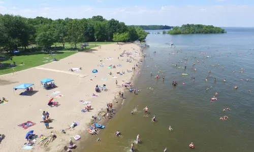 Una veduta aerea di una spiaggia con persone che si godono il sole, la sabbia e l'acqua