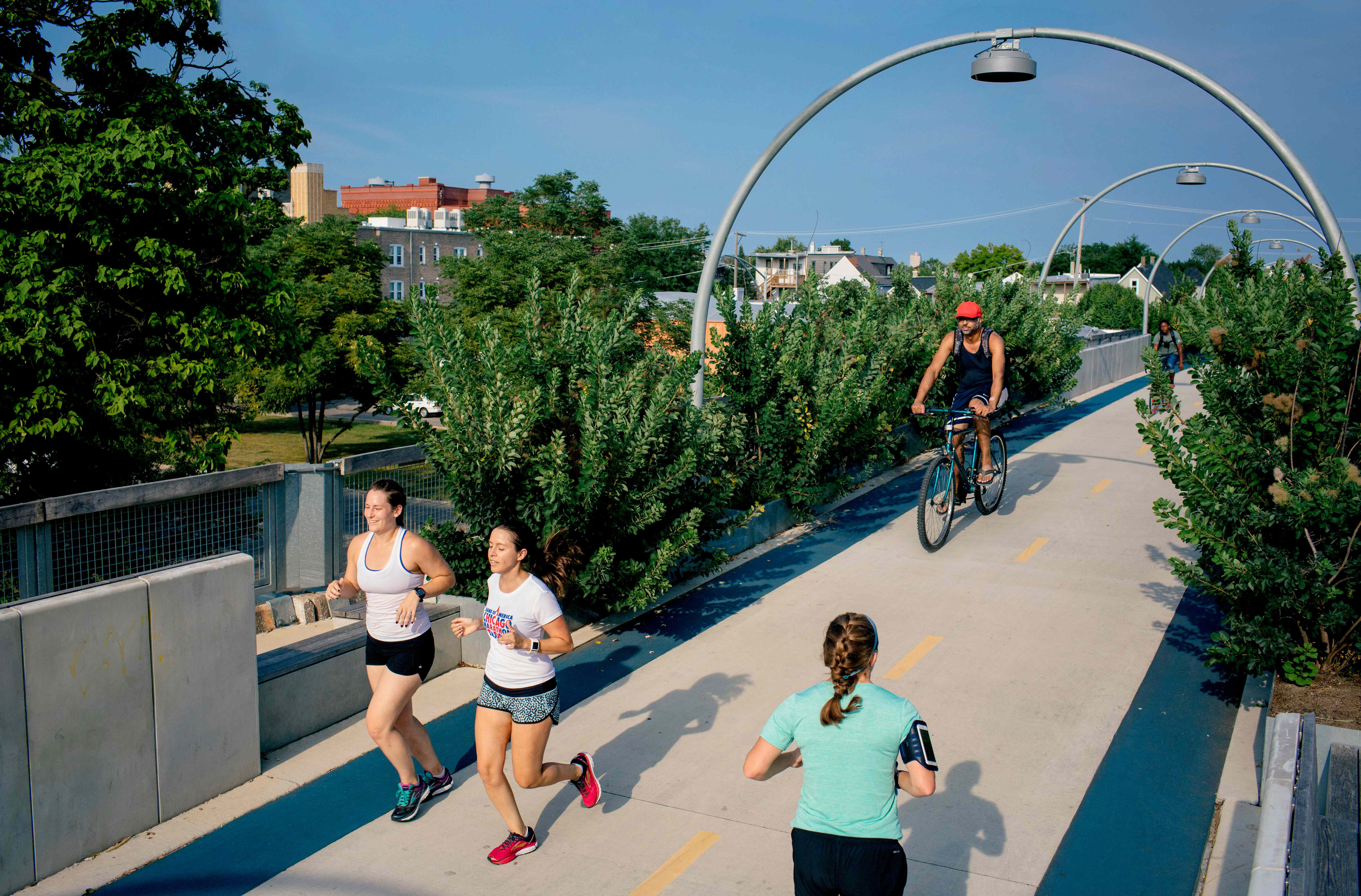 Persone che corrono e vanno in bicicletta sul ponte ciclabile 