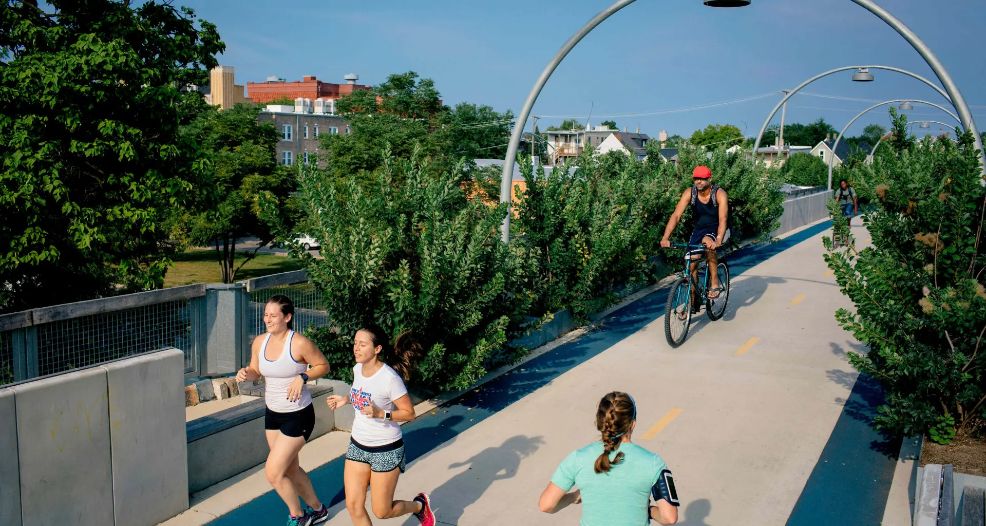 Persone che corrono e vanno in bicicletta sul ponte ciclabile