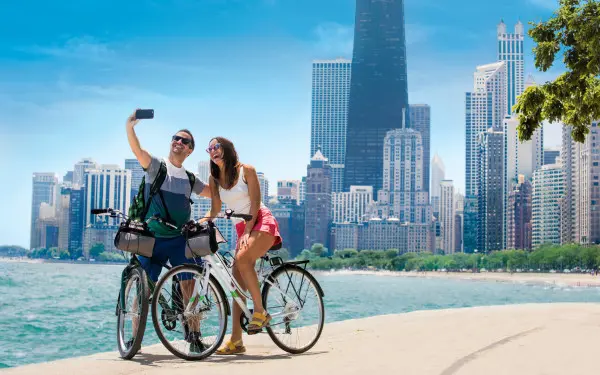 Una coppia in bicicletta lungo il sentiero che costeggia il lago che scatta una fotografia