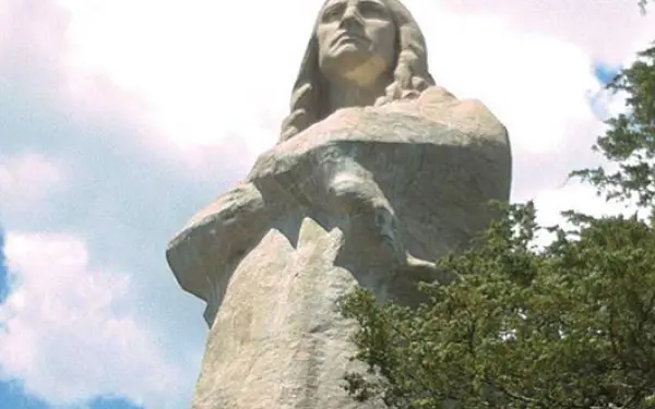 Guardando in alto, la statua del Falco Nero circondata da alberi