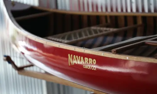Una canoa rossa con il logo Navarro Canoe.